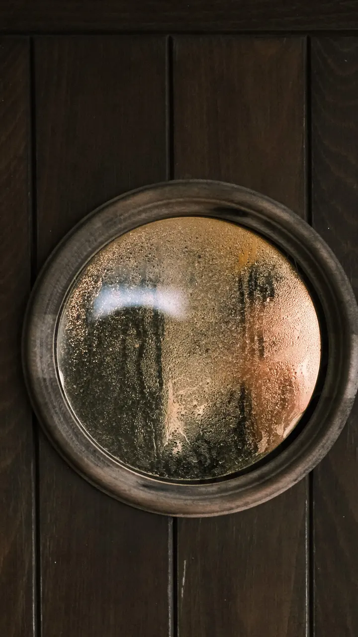 A circular window glowing in a dark wood wall